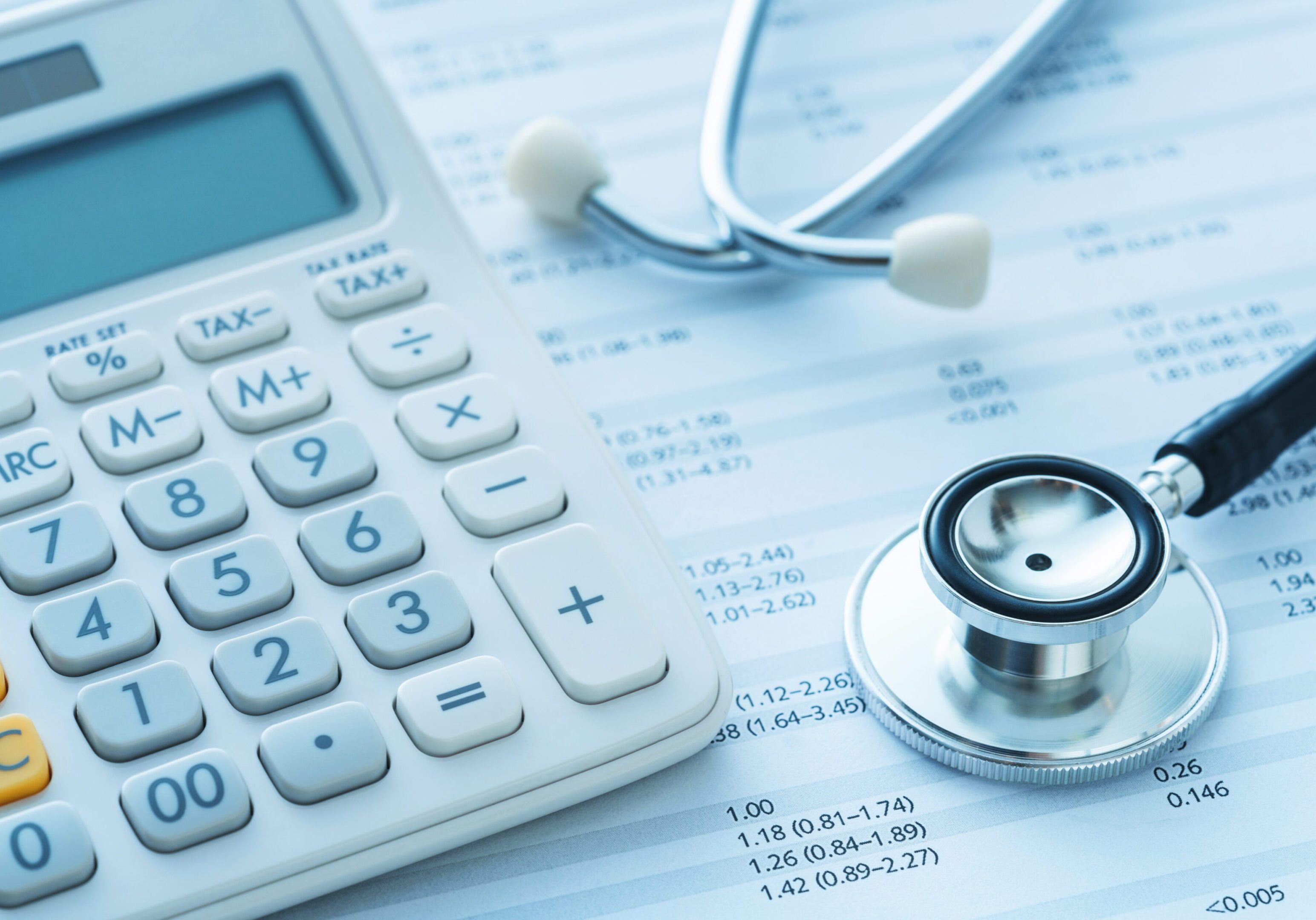 Medical finance insurance A calculator and stethoscope on top of some papers